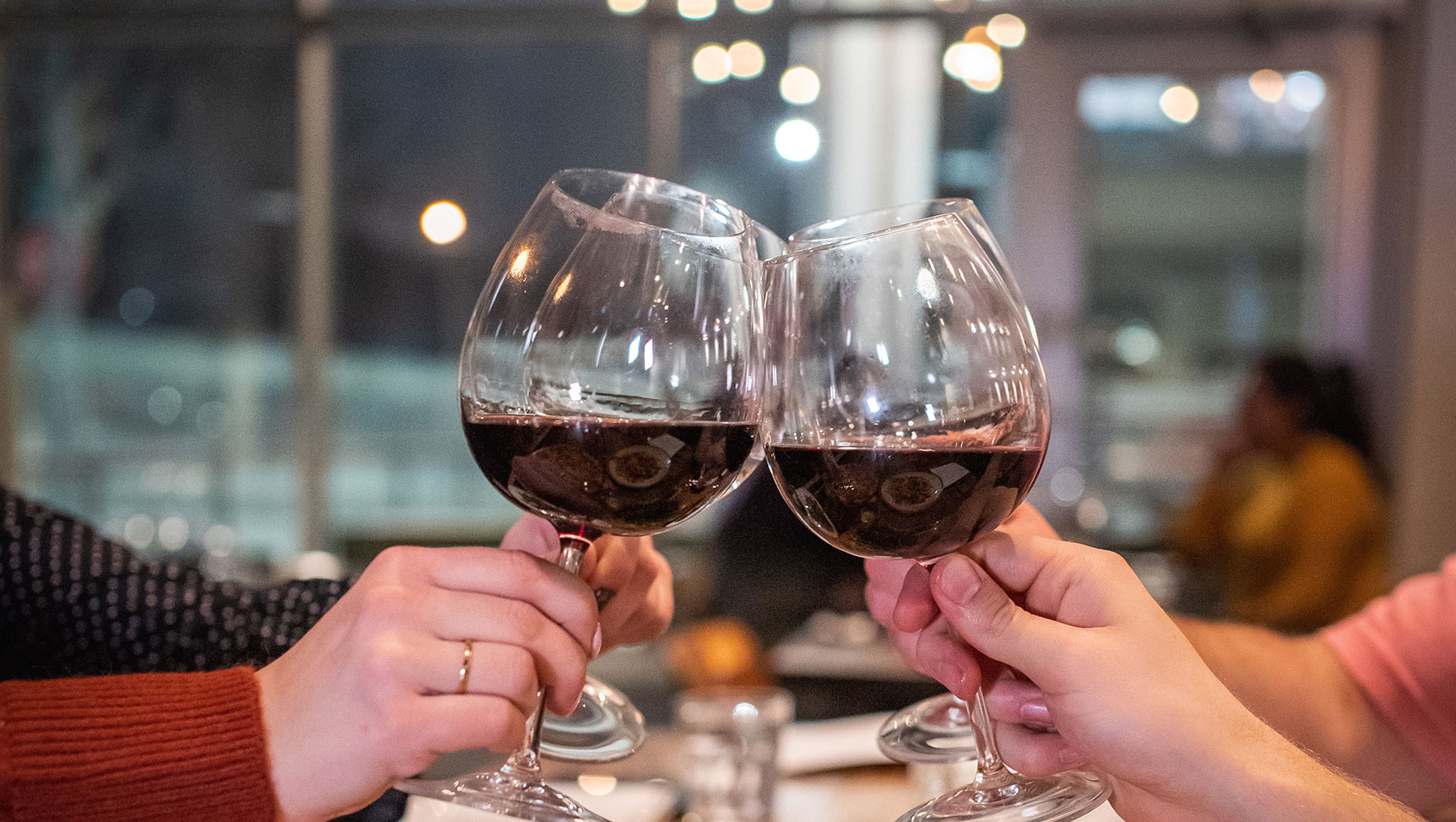 hands toasting with glasses of wine