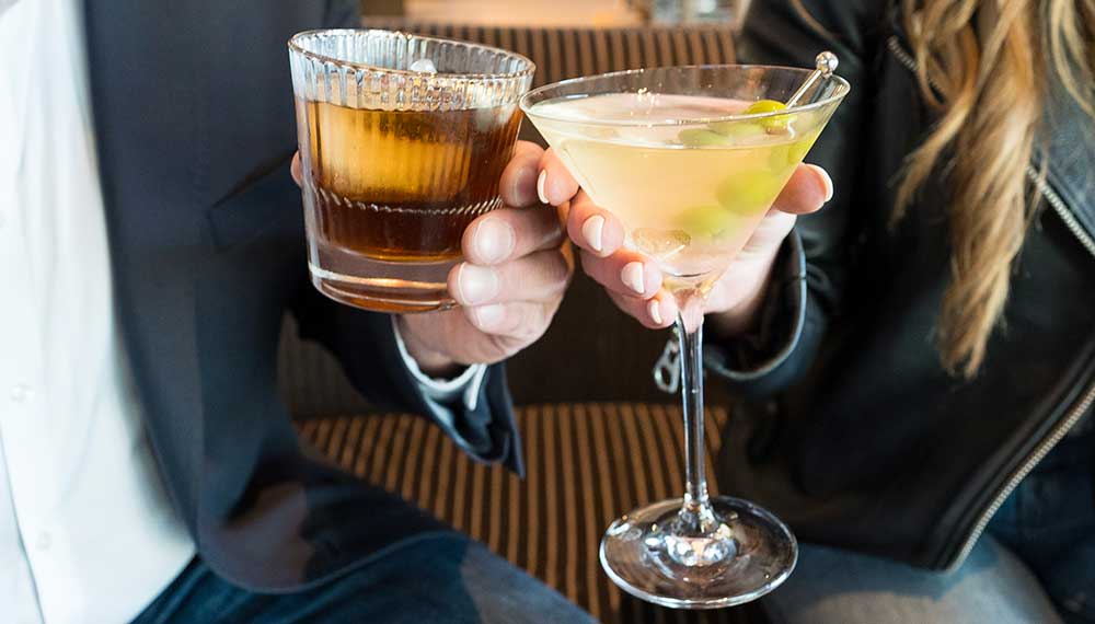 Two people cheersing with cocktails at Saverina
